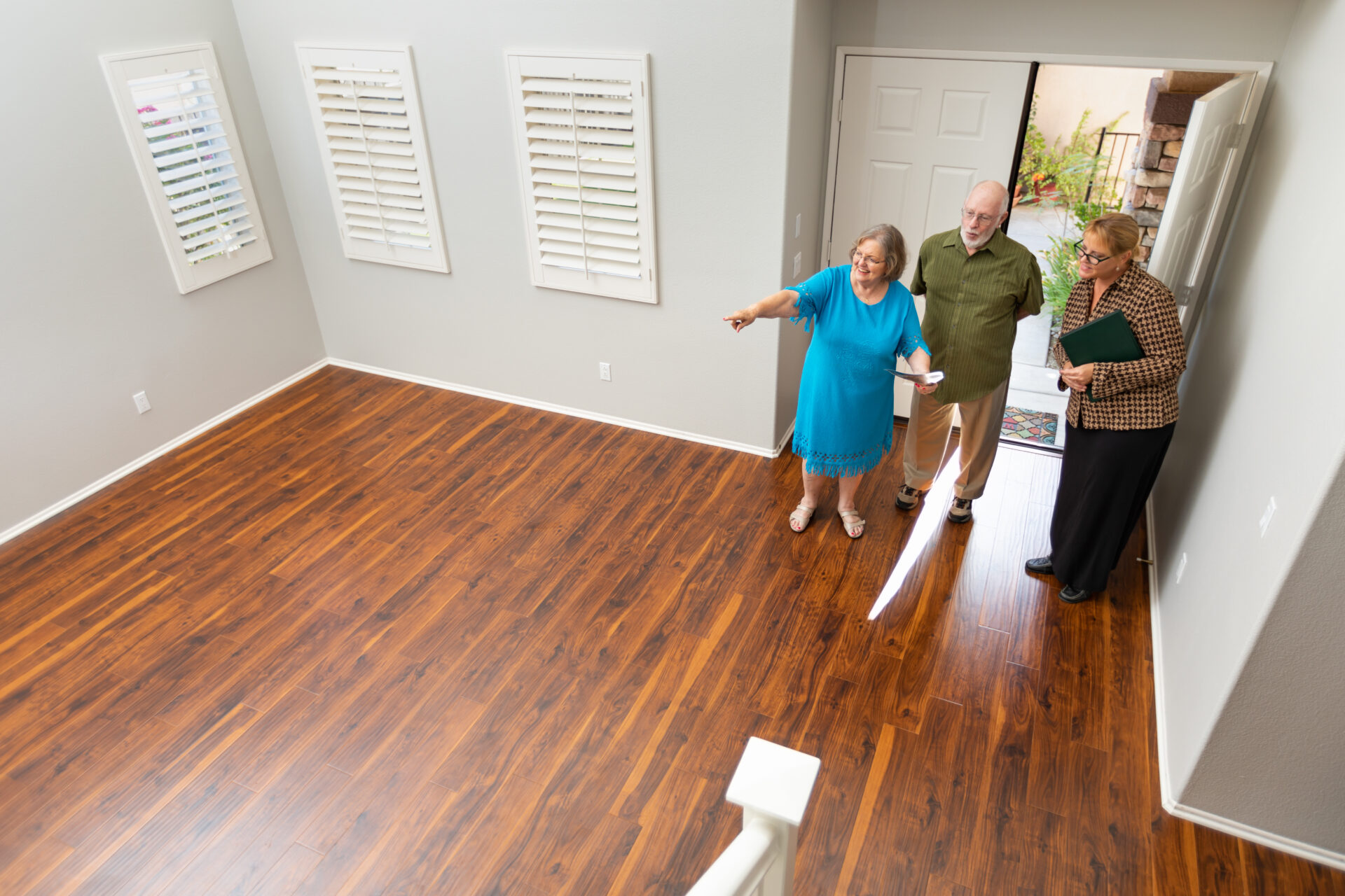 A realtor showing a home with red oak floors.